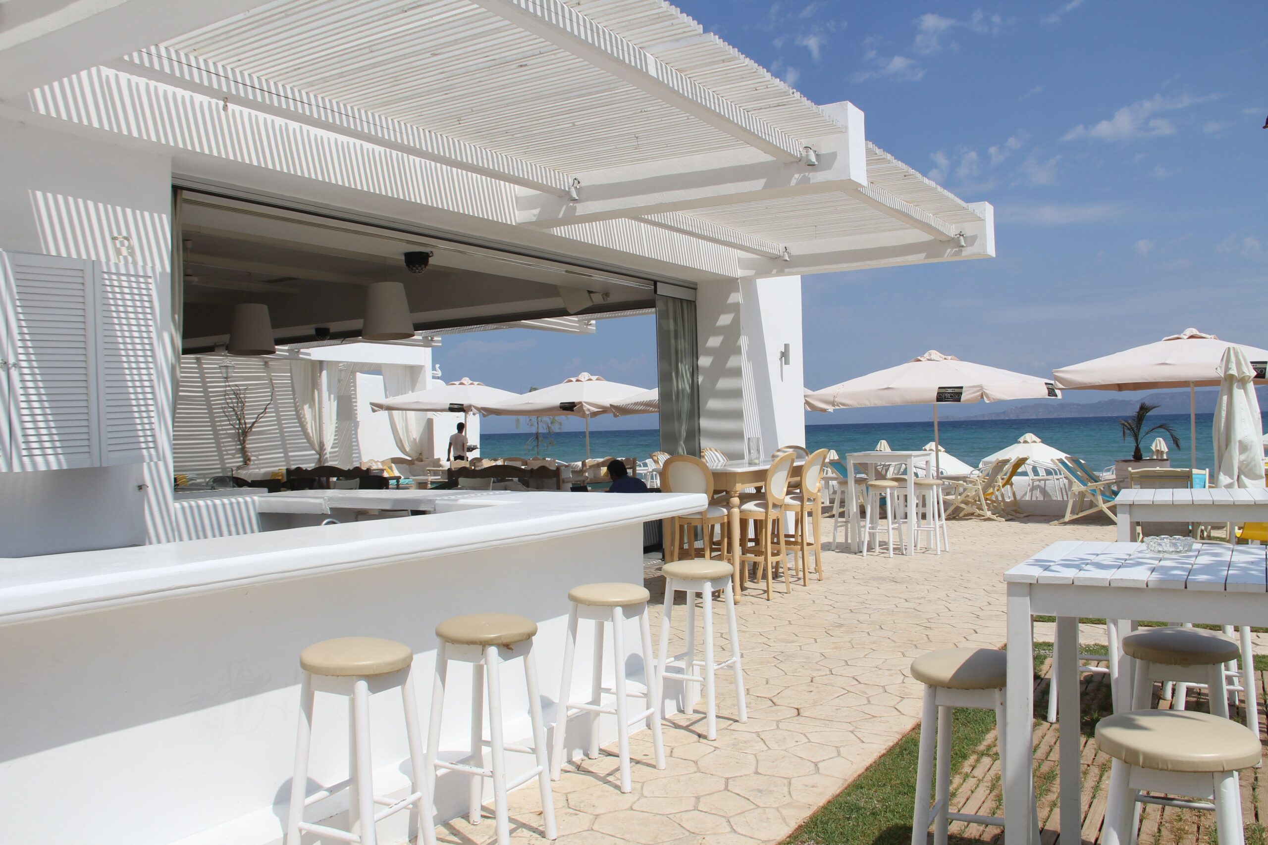 Elegant outdoor bar and restaurant by the ocean, perfect for a luxury vacation.